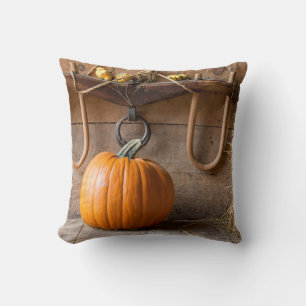 Farmers Museum. Pumpkin in barn with bale of hay Throw Pillow