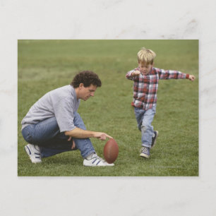 Father and son (4-6) playing American football Postcard