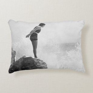 Female swimmer on rock above crashing surfvintage, accent pillow