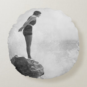 Female swimmer on rock above crashing surfvintage, round pillow