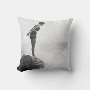Female swimmer on rock above crashing surfvintage, throw pillow