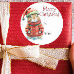 Festive Hamster in Santa Hat Christmas Classic Round Sticker<br><div class="desc">This delightful Christmas sticker features an adorable hamster dressed in festive holiday attire. The hamster is wearing a red coat adorned with white snowflake patterns, topped off with a classic Santa hat. The background is a soft, snowy white, enhancing the wintry theme. Above the charming image, elegant red cursive script...</div>