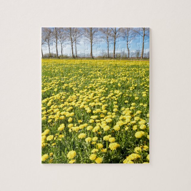 Field of yellow dandelions in grass with tree line jigsaw puzzle (Vertical)