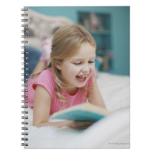 Fille s'étendant dans le livre de lecture de lit