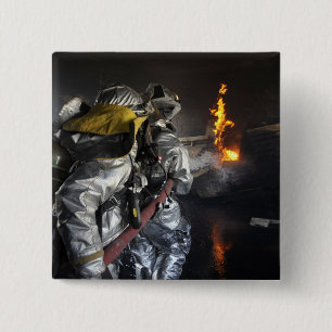 Firefighters extinguish a fire in a training ro 2 inch square button