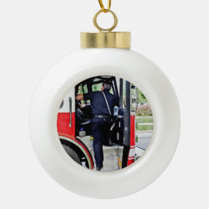 Fireman Climbing into Fire Truck Ceramic Ball Christmas Ornament