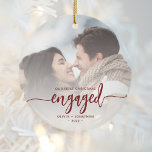 First Christmas Engaged Custom Photo Red Script Ceramic Ornament<br><div class="desc">Commemorate your engagement with this beautiful modern keepsake ornament. The burgundy red text reads "Our first Christmas engaged, " with the word "engaged" in elegant calligraphy script with decorative swashes before and after. Replace the sample image with your favourite photo, and add your names and the year. A white gradient...</div>