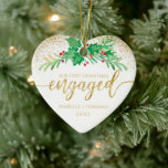 First Christmas Engaged Gold Glitter Holly Photo Ceramic Ornament<br><div class="desc">For your first Christmas engaged this elegant holiday heart shaped ornament features a sprig of holly painted in watercolor accented by faux gold glitter. Below it reads in faux gold glitter script typography "Our First Christmas engaged" with your first names and year to personalize. The back of the ornament features...</div>