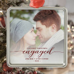 First Christmas Engaged Photo Red Modern Script Metal Ornament<br><div class="desc">Commemorate your engagement with this beautiful modern keepsake ornament. The burgundy red text reads "Our first Christmas engaged, " with the word "engaged" in elegant calligraphy script with decorative swashes before and after. Replace the sample image with your favourite photo, and add your names and the year. A white gradient...</div>