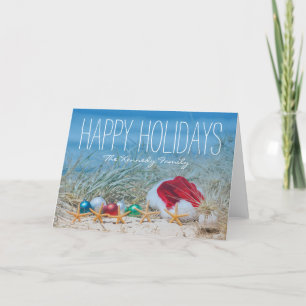 Five starfish on a beach with a Santa hat Holiday Card