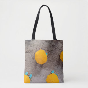 Five yellow umbrellas on sand at daytime tote bag