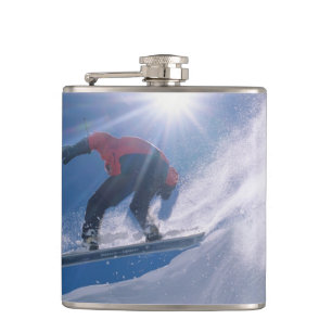 Flasques Homme sautant d'une grande corniche en snowboard