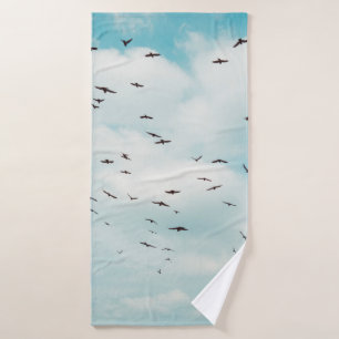 Flock of grey dove fly on vintage blue sky. above, bath towel