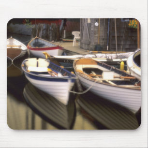 Fog surrounds four boats docked. mouse pad