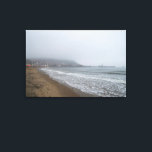 Foggy Morning on South Bay Beach, Scarborough Canvas Print<br><div class="desc">An atmospheric and moody scene of South Bay Beach in Scarborough, North Yorkshire, enveloped in a dense morning fog. Gentle waves lap at the sandy shore in the foreground, creating a foamy edge. The mist partially obscures the vibrant lights of the town and harbor, giving Scarborough a mysterious and ethereal...</div>