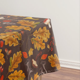 Forest mushrooms and autumn flora on brown tablecloth