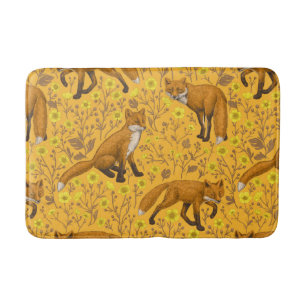 Foxes and buttercups on orange bath mat