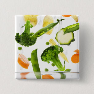 Fresh vegetables with water falling into a bowl 2 inch square button
