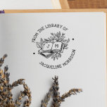From The Library Of Rustic Botanical Book Initials Self-inking Stamp<br><div class="desc">A cute self-inking book stamp with rustic lettering, botanical leaves, and tree branches! "From the library of" and your custom name are written in curved text around the central illustration. The text is in whimsical, handwriting-style capital letters. The illustration features a stack of books, the top book is laying open...</div>