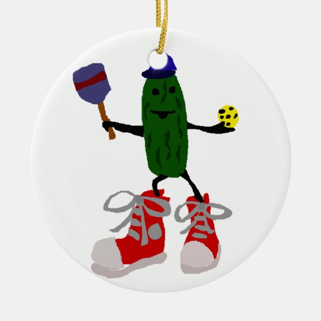 Funny Pickle Holding Pickleball and Paddle Ceramic Ornament (Front)
