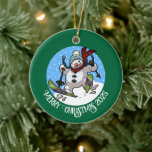 Funny Snowman Merry Christmas Add The Year Cartoon Ceramic Ornament<br><div class="desc">A funny skiing snowman ornament for your Christmas tree. Use "Personalize this template" to tweak the text or year and make a unique customized xmas gift. The tree decoration features a whimsical cartoon of an excited snowman with a carrot nose, dashing downhill through the snow on skis, in woolly winter...</div>