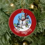 Funny Snowman Merry Christmas! Skiing Cartoon Ceramic Ornament<br><div class="desc">A jolly snowman on a ceramic ornament for your Christmas tree. Use "Personalise this template" to tweak the "Merry Christmas!" text and create a unique, customized gift. Featuring a cute snowman with a carrot nose and coal eyes, dashing through the snow on skis, in woolly winter hat and tartan scarf,...</div>