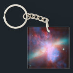 Galaxy M82 Keychain<br><div class="desc">This image shows a stunning view of a Starburst galaxy produced by space telescopes. M82 is a galaxy about 12 million light years from Earth that is undergoing a burst of star formation. X-rays from Chandra (blue) show gas being blasted away from the galaxy's disc as a bounty of stars...</div>