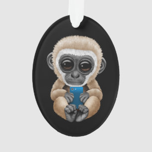 Gibbon mignon de bébé tenant un noir de téléphone