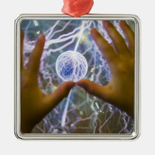Girls hands on a plasma ball metal ornament