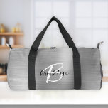 Glam Silver Brushed Metal Black White Monogram  Duffle Bag<br><div class="desc">This personalized duffel bag features a monogram and first name in modern black and white script on a glam silver faux brushed metal background.</div>