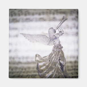 Glass angel playing trumpet and image of sheet magnet