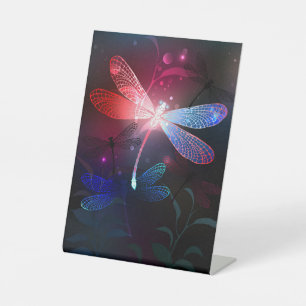 Glowing red dragonfly pedestal sign