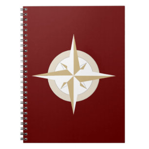 Gold and White Compass on Red Notebook