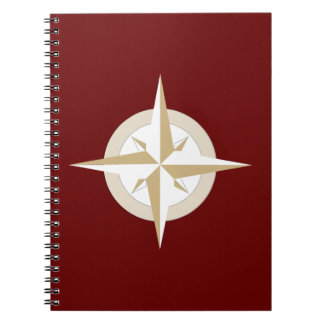 Gold and White Compass on Red Notebook