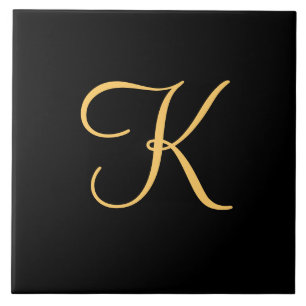 Gold-coloured initial K on black background Tile
