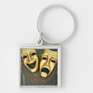 Golden comedy and tragedy masks on patterned keychain