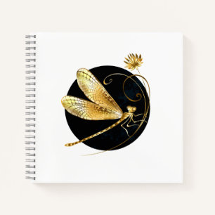 Golden dragonfly in black circle notebook