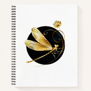 Golden dragonfly in black circle notebook