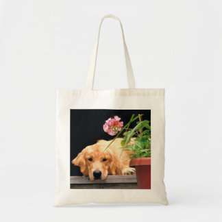 Golden retriever avec le sac fourre-tout à fleur