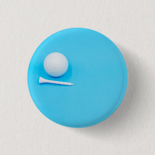 Golf ball and tee are on blue background 1 inch round button