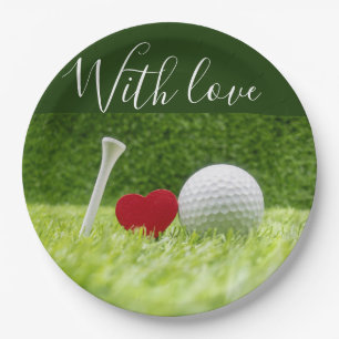 Golf ball and tee on green grass with love paper plate