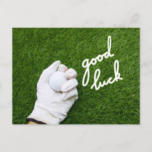 Golf ball in hand with GOOD LUCK word on green Postcard