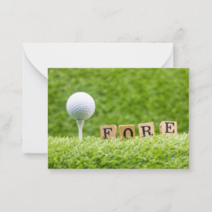 Golf ball is on green grass with word FORE Card