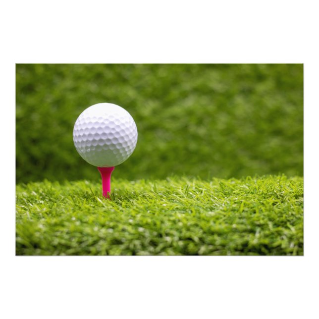 Golf ball is on pink tee on green grass background photo print (Front)