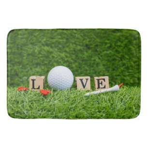 Golf ball with LOVE word and tee on green grass Bath Mat