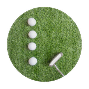 Golf balls are on green grass cutting board