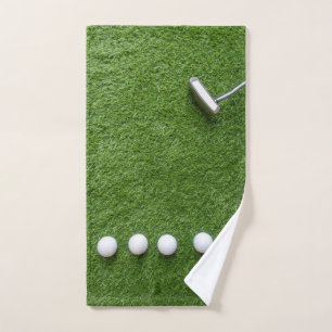 Golf balls with Putter are on green grass Hand Towel