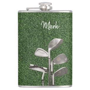 Golf iron on green grass hip flask