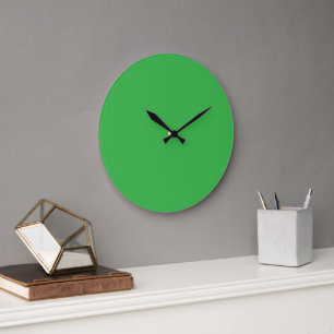 Grande Horloge Ronde Un écran vert vif posé contre un bar blanc propre