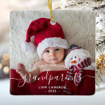 Grandparents First Christmas Photo White Script Ceramic Ornament<br><div class="desc">Help them celebrate their first grandchild with this beautiful modern keepsake ornament. The off-black text reads "Our first Christmas as grandparents, " with the word "grandparents" in elegant handwriting script with flourishes before and after. Easily replace the sample image with your favorite photo of the new baby, and add his...</div>